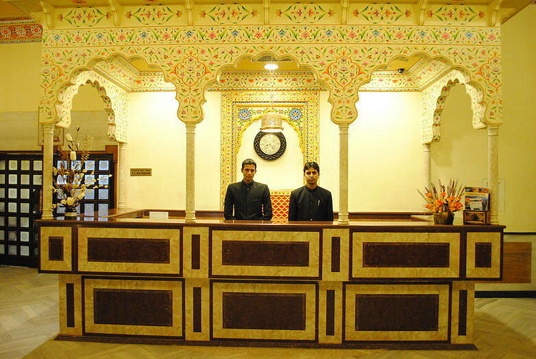 Reception front desk with staff at Fort Chandragupt Hotel Jaipur